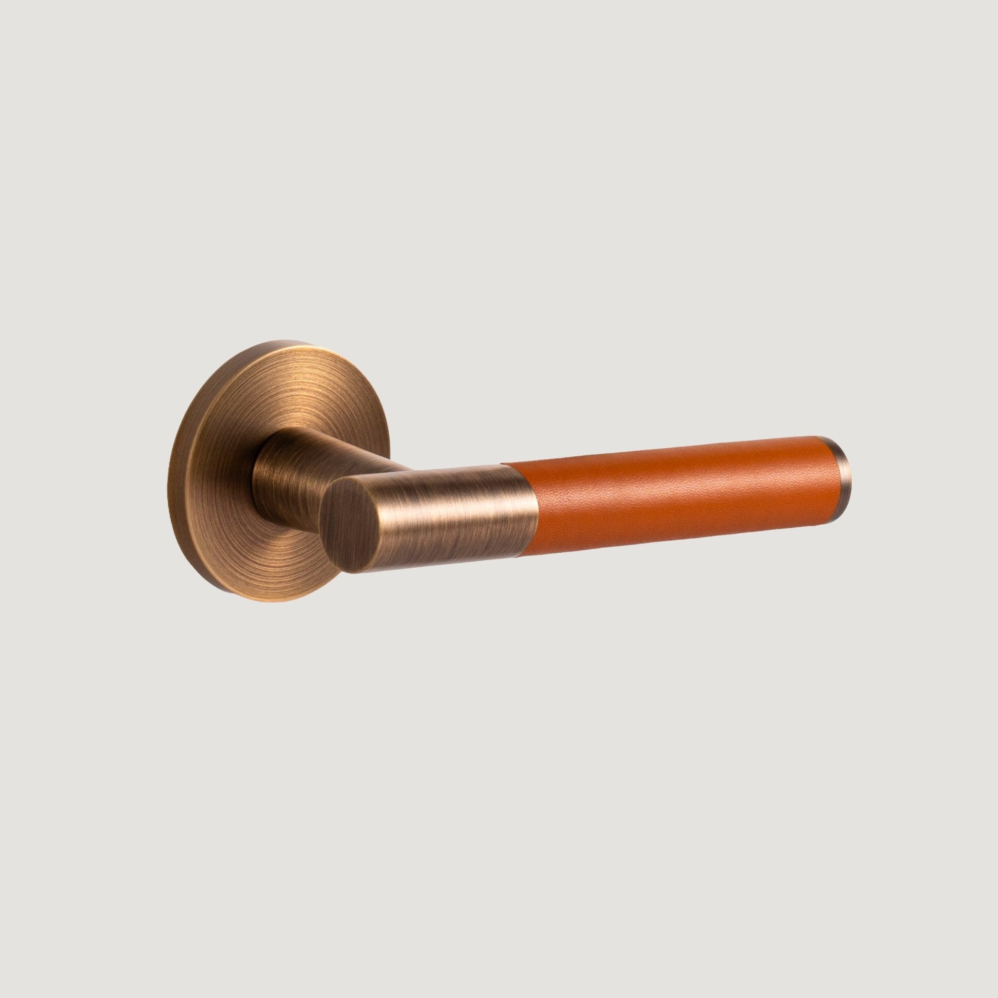 Cavallo solid brass door lever with deep Antique Brass proud-standing rose and hand-stitched orange leather grip — Bergamo Design