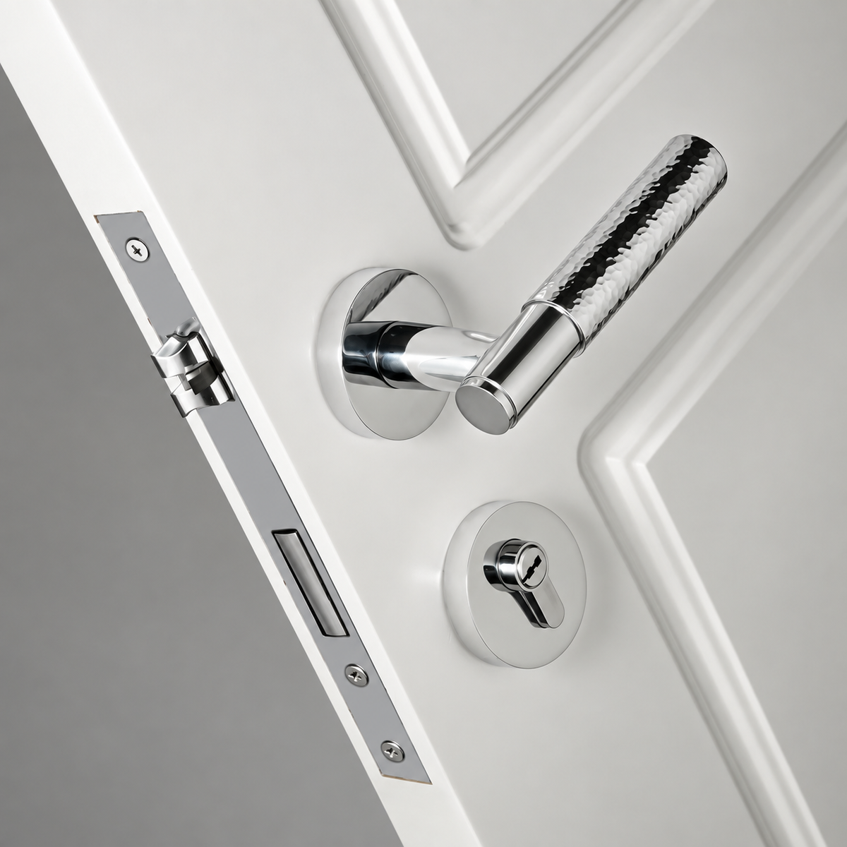 Polished Nickel Martello hammered door lever and lock installed on a white panelled door — Bergamo Design