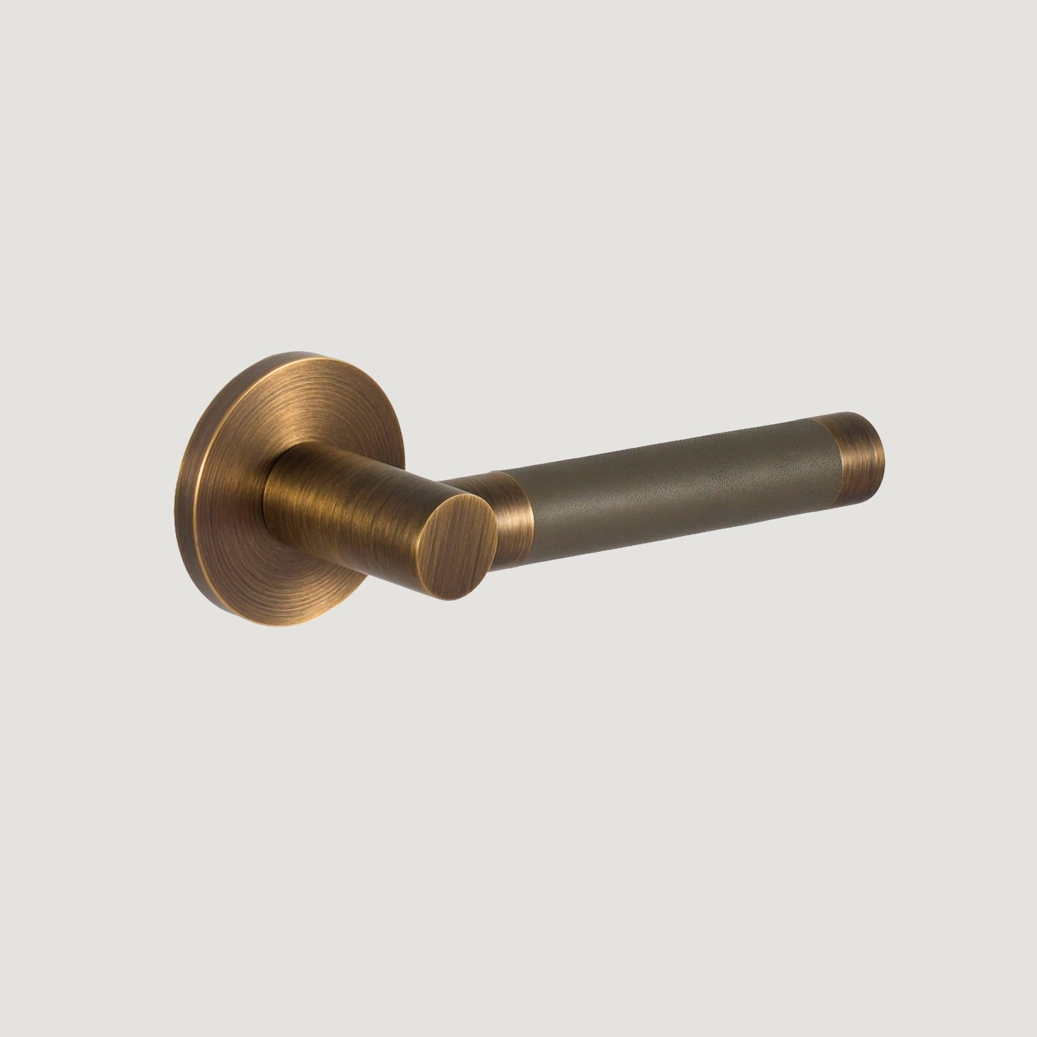 Cavallo Piatto solid brass door lever with deep Antique Brass frame and hand-stitched grey leather grip — Bergamo Design