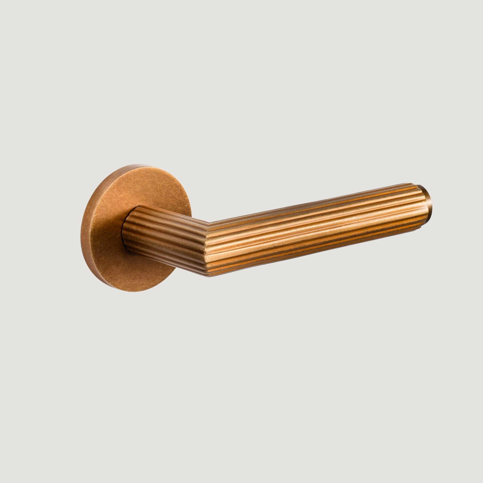 Ornato solid brass door lever with fluted form and flat rose — Aged Brass, Bergamo Design